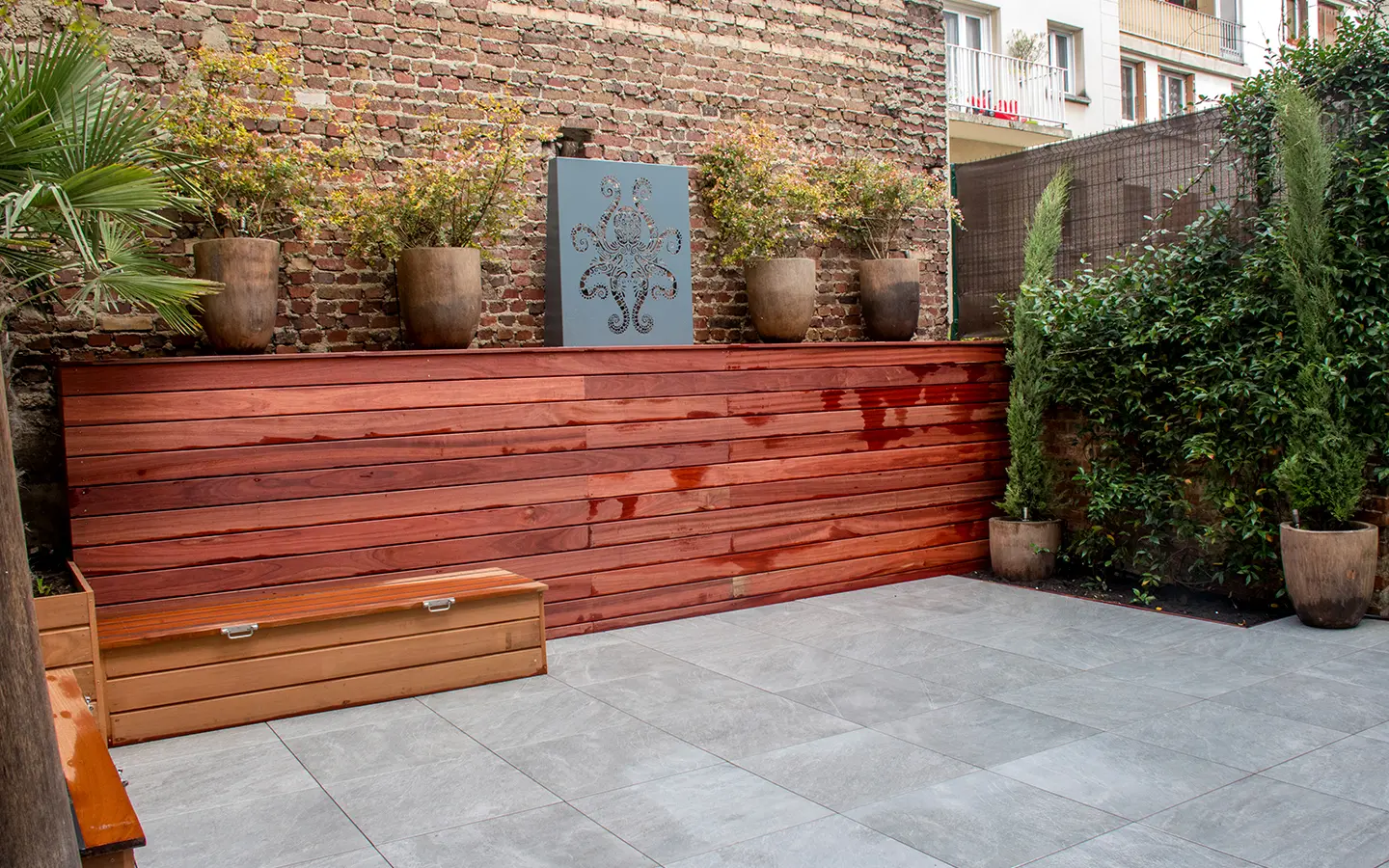 Rénovation du jardin arrière de 50m² d'une maison individuelle à Asnières-sur-Seine, avec une mise en avant de matériaux de caractères.