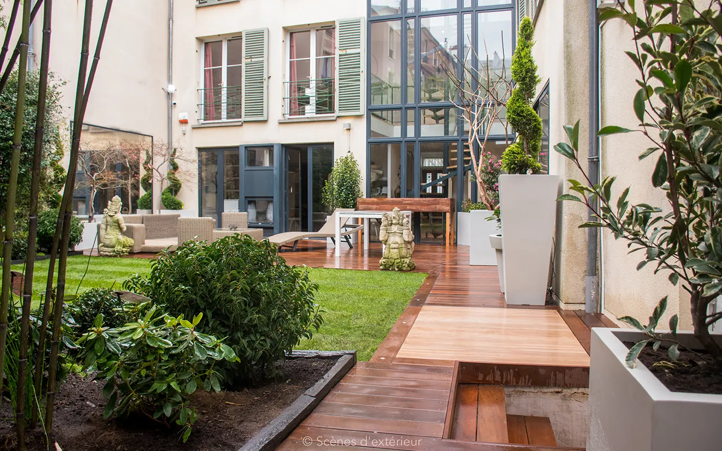 Création d'un espace paysager à l'ambiance seraine, mêlant un espace terrasse sur bois exotique, et d'un jardin sur gazon en plaque au pourtour végétal ordonné