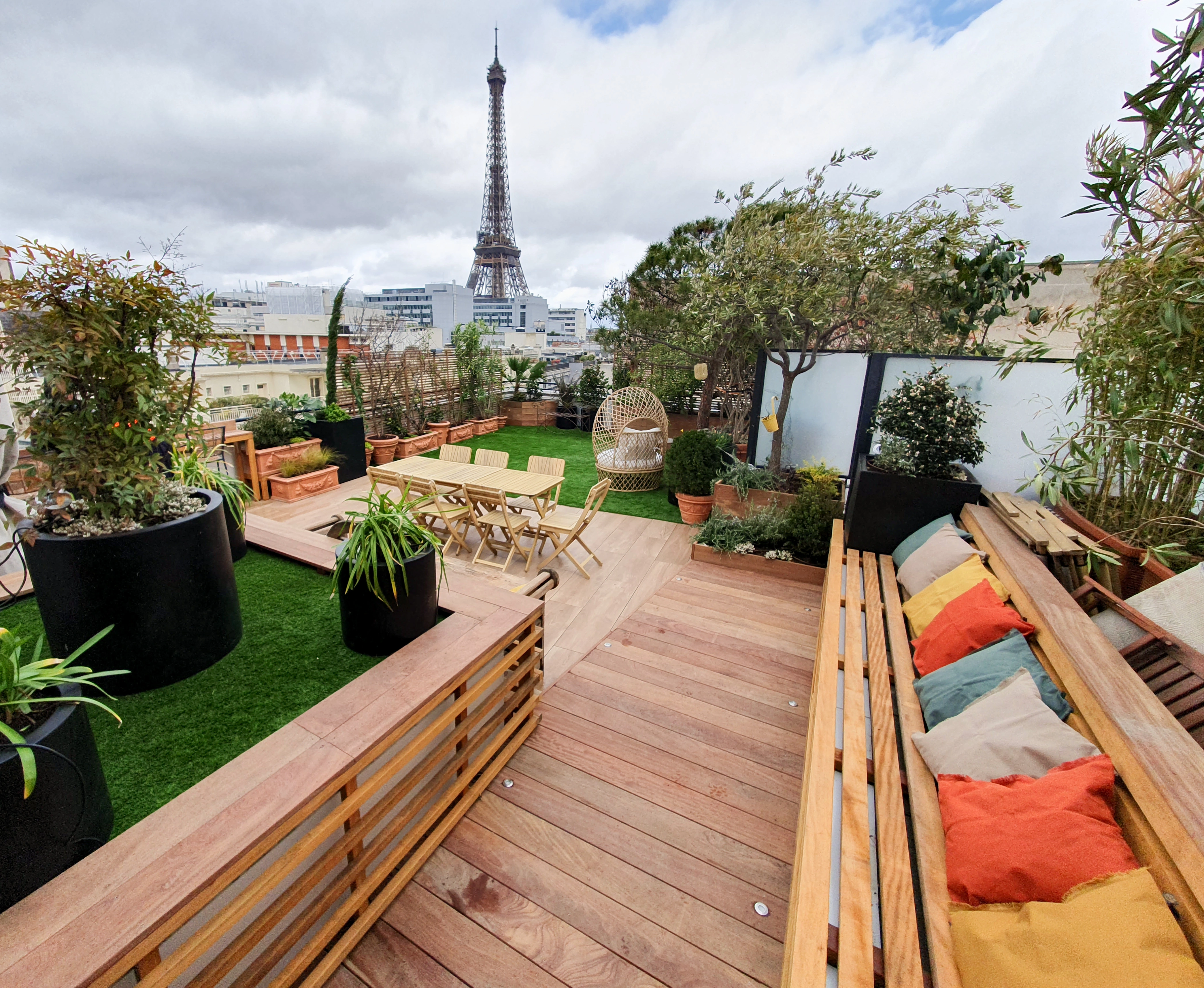 Conception et réalisation d'une terrasse arborée, deck en bois exotique, gazon synthétique, menuiserie sur mesure et espace lounge.