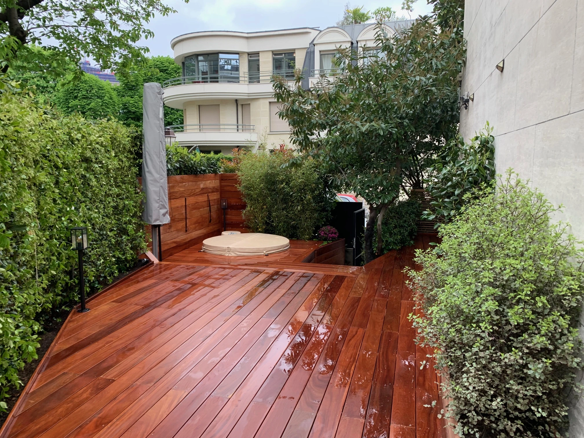 Conception et réalisation d'une terrasse en bois exotique, de plantations, d'intégration d'un jacuzzi, d'un parasol déporté.
